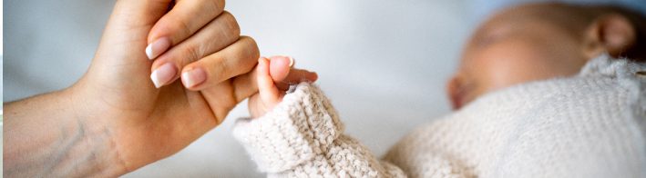 mom holding baby's hands